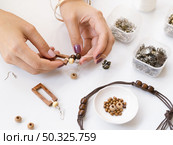 woman making accessories with wooden beads. Resolution and high quality beautiful photo. woman making accessories with wooden beads. High quality and resolution beautiful photo concept. Стоковое фото, агентство Ingram Publishing / Фотобанк Лори