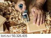 carpenter working wood surrounded by sawdust. Resolution and high quality beautiful photo. carpenter working wood surrounded by sawdust. High quality beautiful photo concept. Стоковое фото, агентство Ingram Publishing / Фотобанк Лори