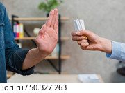man refusing bunch cigarettes offered by his female friend. High resolution photo. man refusing bunch cigarettes offered by his female friend. High quality photo. Стоковое фото, агентство Ingram Publishing / Фотобанк Лори