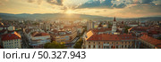 A panoramic sunset casts a warm glow over a city, highlighting the historic buildings and bustling streets. Стоковое AI-изображение, AI-художник Данила Большаков / Фотобанк Лори