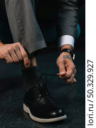 low section businessman s hand tying shoelace. High resolution photo. low section businessman s hand tying shoelace. High quality photo. Стоковое фото, агентство Ingram Publishing / Фотобанк Лори