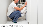 man putting clothes washing machine. High resolution photo. man putting clothes washing machine. High quality photo. Стоковое фото, агентство Ingram Publishing / Фотобанк Лори