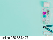 thread spool pearls case plier bracelet teal backdrop with copy space writing text. Стоковое фото, агентство Ingram Publishing / Фотобанк Лори