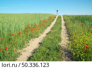 Man walking away and jump on pathway at green spring meadow. Стоковое фото, агентство Ingram Publishing / Фотобанк Лори