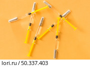 elevated view medical syringes yellow background. Стоковое фото, агентство Ingram Publishing / Фотобанк Лори