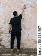 graffiti artist painting with spray can dirty wall. Стоковое фото, агентство Ingram Publishing / Фотобанк Лори