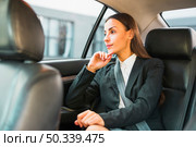 businesswoman looking through window while traveling by car. Стоковое фото, агентство Ingram Publishing / Фотобанк Лори