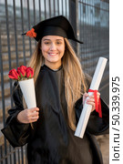 front view graduate with bouquet roses. Стоковое фото, агентство Ingram Publishing / Фотобанк Лори