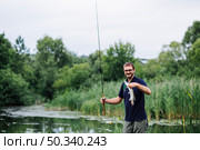 man holding fishing rod with fish hook. Стоковое фото, агентство Ingram Publishing / Фотобанк Лори
