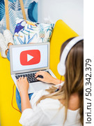 woman sitting with opened laptop headphones. Стоковое фото, агентство Ingram Publishing / Фотобанк Лори