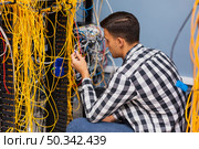 young network engineer working with wires. Стоковое фото, агентство Ingram Publishing / Фотобанк Лори