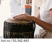 young person playing latin percussion instrument. Стоковое фото, агентство Ingram Publishing / Фотобанк Лори