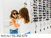 child wearing sunglasses looking mirror. Стоковое фото, агентство Ingram Publishing / Фотобанк Лори