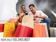 amazed young couple looking inside shopping bags. Стоковое фото, агентство Ingram Publishing / Фотобанк Лори