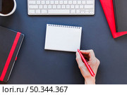 faceless person writing notebook near coffee cup keyboard. Стоковое фото, агентство Ingram Publishing / Фотобанк Лори