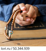 person holding rosary hands praying. Стоковое фото, агентство Ingram Publishing / Фотобанк Лори