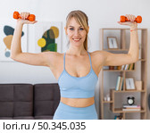 portrait woman training home with weights. Стоковое фото, агентство Ingram Publishing / Фотобанк Лори