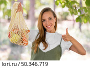 woman doing thumbs up sign biodegradable bag with goodies. Стоковое фото, агентство Ingram Publishing / Фотобанк Лори