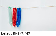 OLYMPUS DIGITAL CAMERA. colourful condoms clothesline with white background. Стоковое фото, агентство Ingram Publishing / Фотобанк Лори