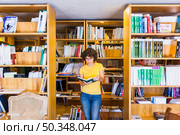 learning lady standing bookcases. Стоковое фото, агентство Ingram Publishing / Фотобанк Лори