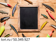 different type fishing lures around black wooden slate wooden backdrop. Стоковое фото, агентство Ingram Publishing / Фотобанк Лори