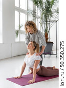 yoga teacher helping woman. Стоковое фото, агентство Ingram Publishing / Фотобанк Лори