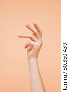 sideview woman s hand pale orange background. Стоковое фото, агентство Ingram Publishing / Фотобанк Лори
