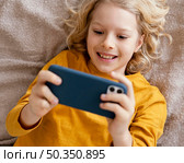 boy bed playing mobile. Стоковое фото, агентство Ingram Publishing / Фотобанк Лори
