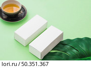 herbal tea cup two white boxes with leaf green background. Стоковое фото, агентство Ingram Publishing / Фотобанк Лори