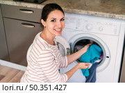lady putting clothes washing machine. Стоковое фото, агентство Ingram Publishing / Фотобанк Лори