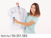 medium shot happy woman using lint roller. Стоковое фото, агентство Ingram Publishing / Фотобанк Лори
