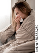 young woman blowing her nose. Стоковое фото, агентство Ingram Publishing / Фотобанк Лори