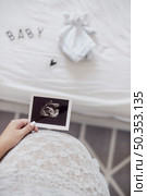 mother holding x ray fetus close her belly. Стоковое фото, агентство Ingram Publishing / Фотобанк Лори
