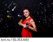 young smiling woman with popper tossing confetti. Стоковое фото, агентство Ingram Publishing / Фотобанк Лори