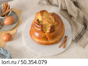 Fogaca on kitchen countertop with eggs and cinammon sticks. Traditional cake from Santa Maria da Feira, Portugal. Стоковое фото, агентство Ingram Publishing / Фотобанк Лори