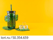 glass cactus juice jar crystal ice cubes leaves coasters against yellow backdrop. Стоковое фото, агентство Ingram Publishing / Фотобанк Лори