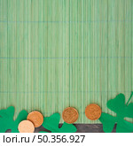 paper clovers near coins bamboo mat. Стоковое фото, агентство Ingram Publishing / Фотобанк Лори
