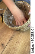 Woman reviewing souvenir wicker storage basket. Vertical video. Стоковое видео, видеограф Vadzim Yakubovich / Фотобанк Лори