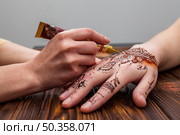 artist making mehndi womans hand table. Стоковое фото, агентство Ingram Publishing / Фотобанк Лори