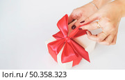 close up woman s hand unwrapping gift box white background. Стоковое фото, агентство Ingram Publishing / Фотобанк Лори