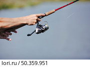 fisherman s hand fishing blurred background. Стоковое фото, агентство Ingram Publishing / Фотобанк Лори