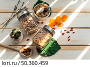 OLYMPUS DIGITAL CAMERA. jar granola cornflakes near dry fruits wooden background. Стоковое фото, агентство Ingram Publishing / Фотобанк Лори