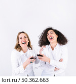 laughing women clinking glasses. Стоковое фото, агентство Ingram Publishing / Фотобанк Лори