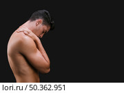 muscular guy rubbing shoulder. Стоковое фото, агентство Ingram Publishing / Фотобанк Лори
