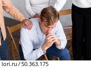 sad man sitting chair group therapy session. Стоковое фото, агентство Ingram Publishing / Фотобанк Лори