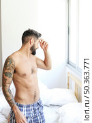 young man kneeling bed morning. Стоковое фото, агентство Ingram Publishing / Фотобанк Лори