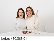 smiling women playing checkers. Стоковое фото, агентство Ingram Publishing / Фотобанк Лори
