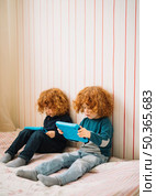 close up twins with red headed hair looking digital tablet. Стоковое фото, агентство Ingram Publishing / Фотобанк Лори