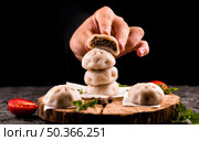 hand holding meat dumpling. Стоковое фото, агентство Ingram Publishing / Фотобанк Лори