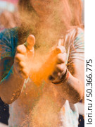 portrait woman dusting holi powder with hands. Стоковое фото, агентство Ingram Publishing / Фотобанк Лори